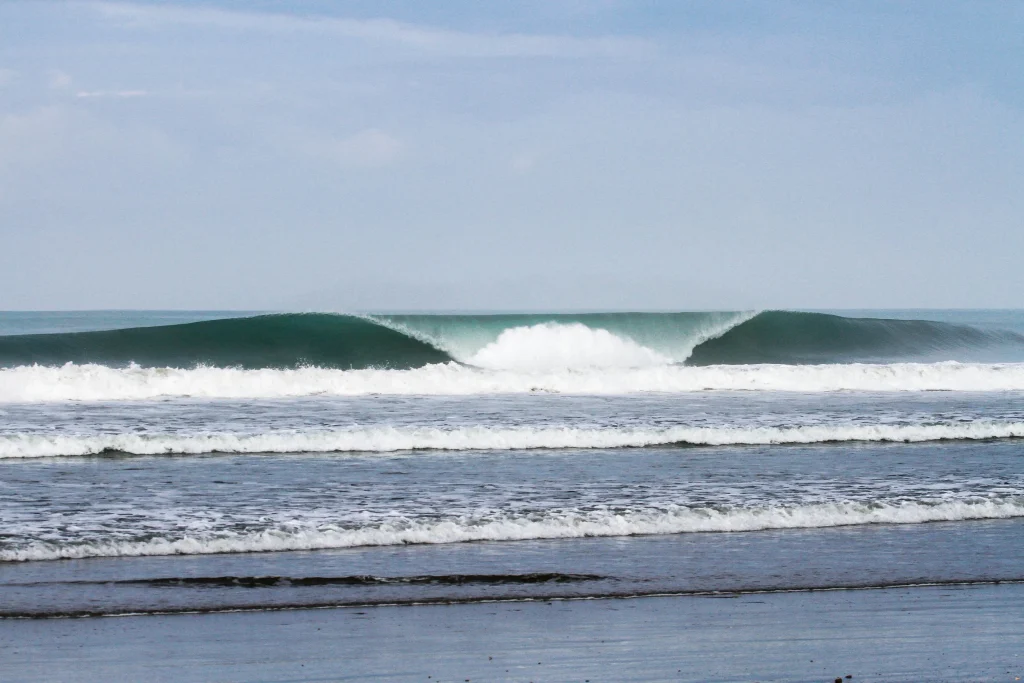 Empty A-frame wave peeling over a sandbar at a Manabi beach break, Ecuador