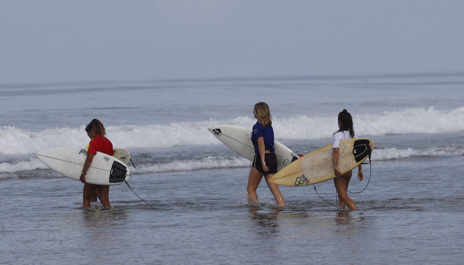 Group of surfer girls getting in the water. Manabi, Ecuador