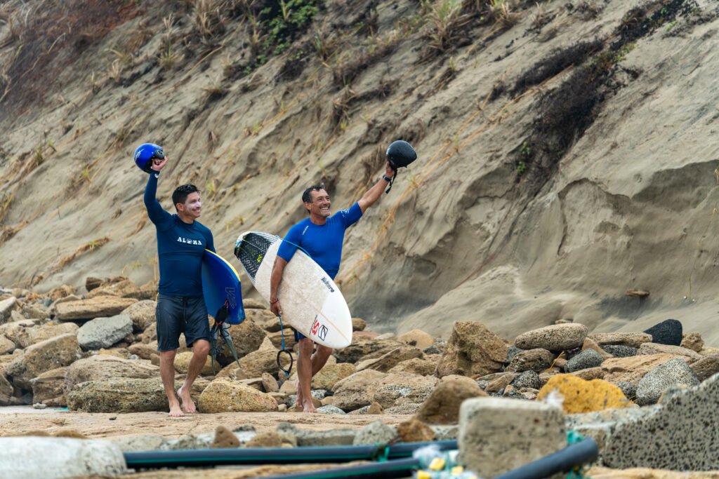 Surfer waving at crowd after surfing